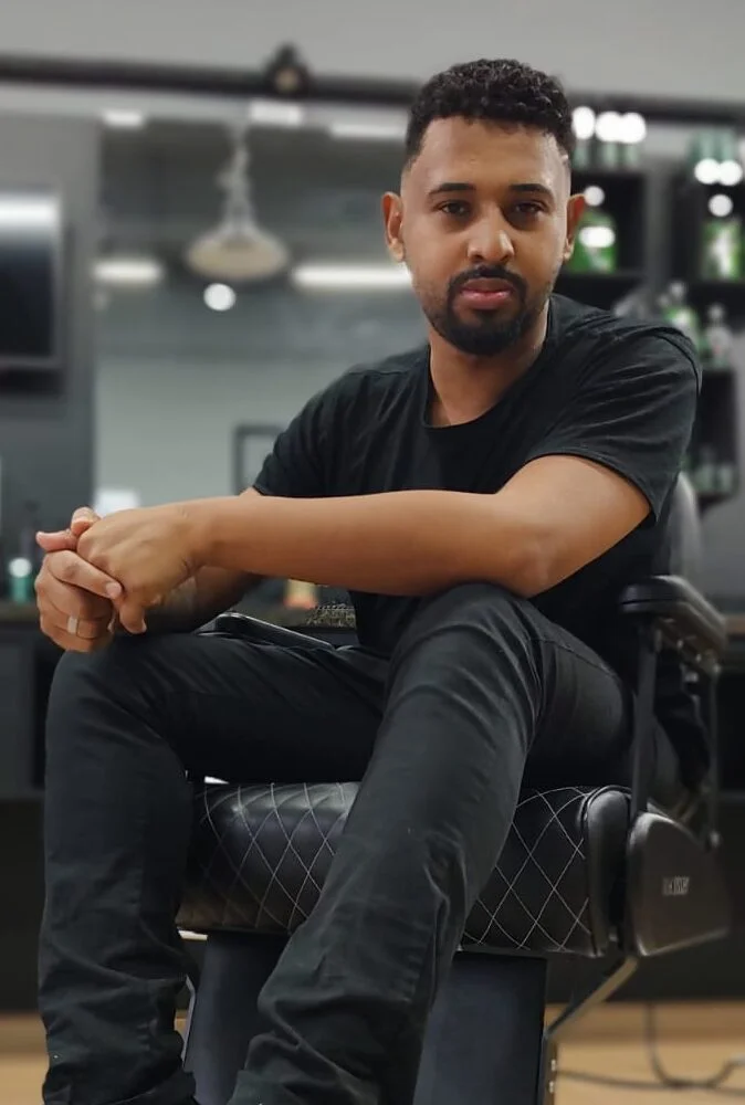 Meu nome é Jhony Henrique, tenho 28 anos e atuo como barbeiro há 5 anos. Já trabalhei em vários lugares, em diversas profissões, mas não me sentia realizado. Ser barbeiro não é só uma profissão, é um estilo de vida. Amo o que faço e sinto-me realizado ao tirar um sorriso de um cliente e por atuar nessa profissão tão antiga e cheia de história.